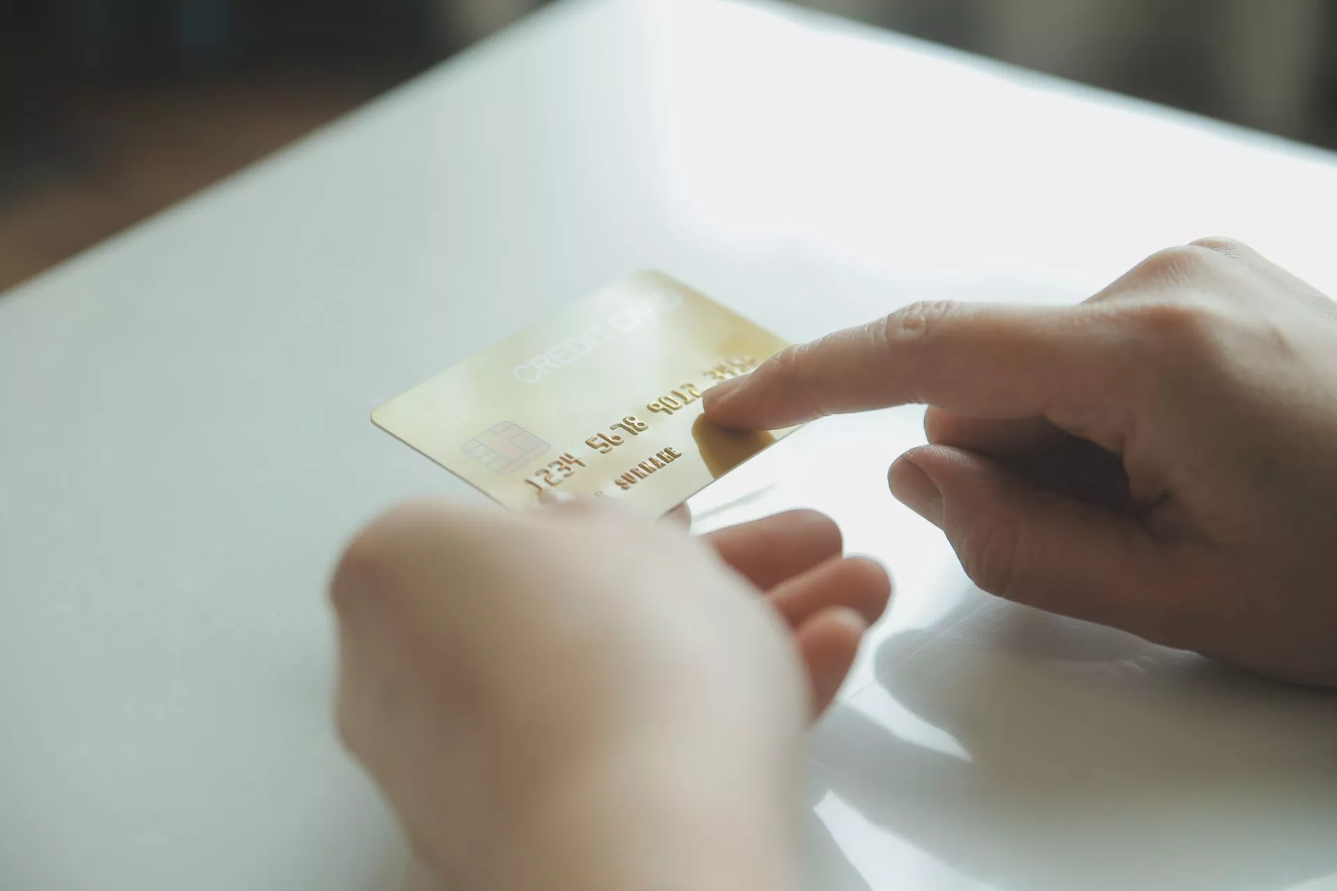 手持信用卡進行操作的近距離畫面，呈現線上刷卡換現金與信用卡額度運用情境，象徵上班族短期資金周轉與金融支付流程