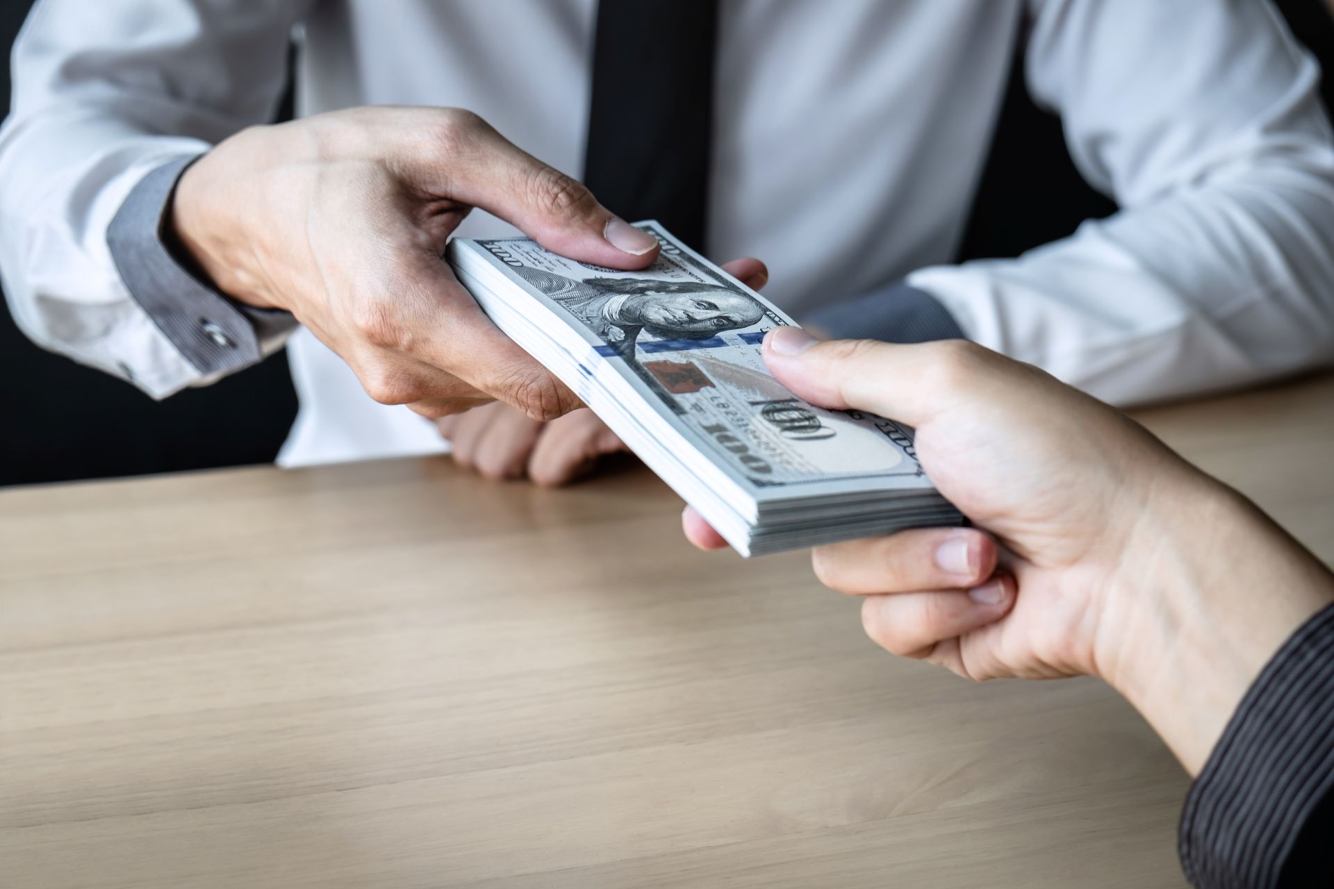 雙方在辦公桌前交付現金，呈現銀行照會、線上刷卡換現金、短期資金週轉與交易安全確認情境示意。